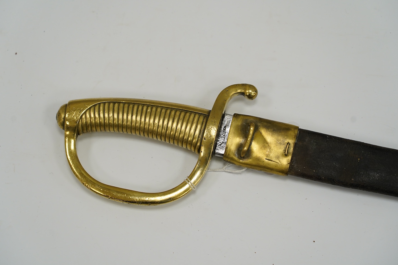 A French briquet cast D-shaped brass hilt in its brass mounted leather scabbard, blade 59.5cm. Condition - fair, blade heavily cleaned